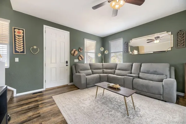 a living room with furniture and a wooden floor