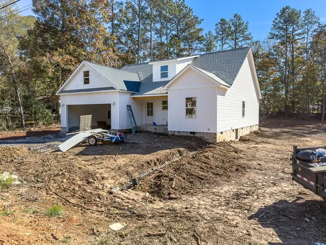 a view of a house with backyard and trees