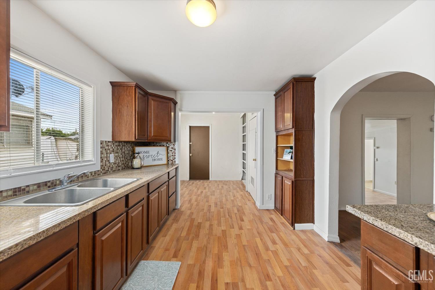 Undisclosed Address Bakersfield, CA 93308 - Photo 13 of 32 a kitchen with granite countertop a sink stove and cabinets
