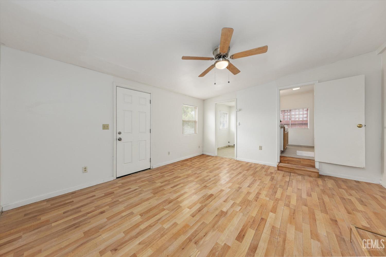 Undisclosed Address Bakersfield, CA 93308 - Photo 17 of 32 a view of empty room with wooden floor and fan