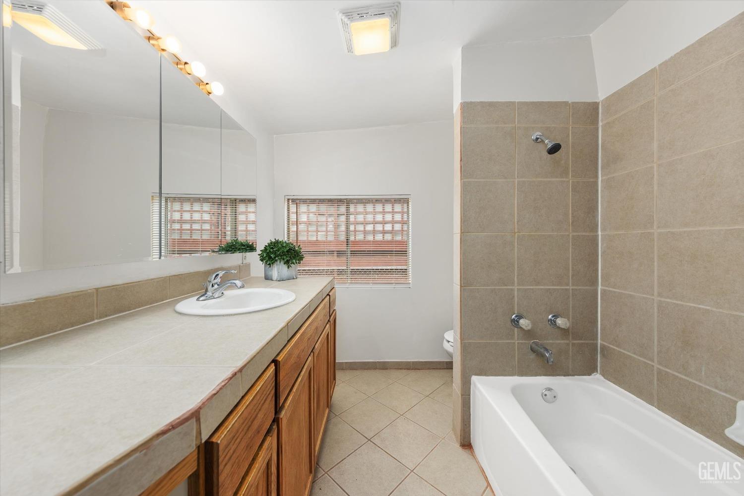 Undisclosed Address Bakersfield, CA 93308 - Photo 20 of 32 a bathroom with a granite countertop sink a bathtub and shower
