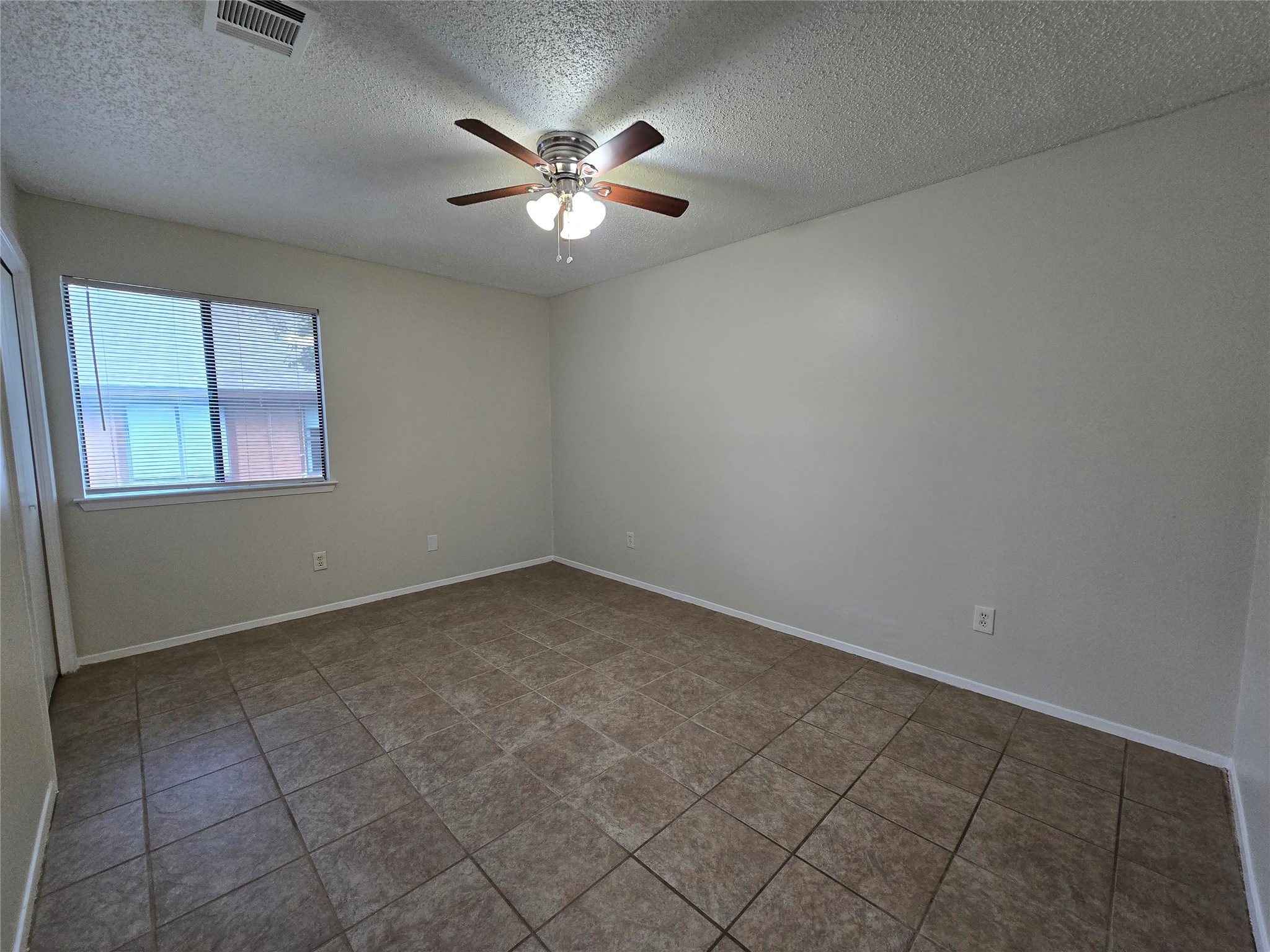 6206 Buffalo Pass, Unit A Austin, TX 78745 - Photo 12 of 24 A well-lit room with durable tile flooring and a ceiling fan for year-round comfort.