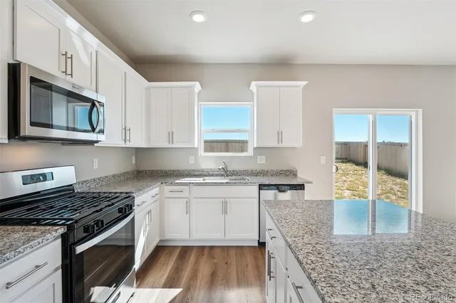 a kitchen with stainless steel appliances granite countertop a stove and a sink