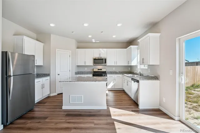 a kitchen with a refrigerator and a stove top oven
