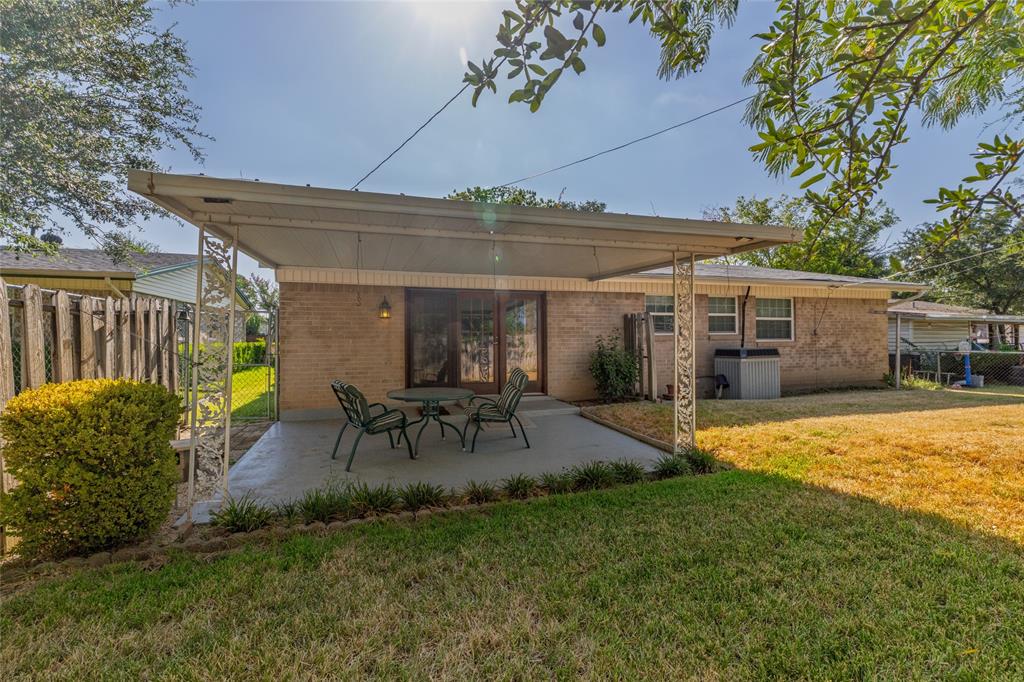 3605 Pleasant Run Road Irving, TX 75062 - Photo 6 of 32 Backyard featuring a covered patio, brick exterior, sliding glass doors, and a manicured lawn