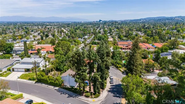 an aerial view of residential houses with outdoor space and trees