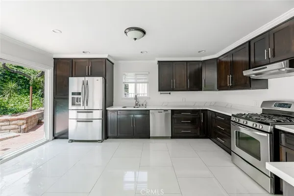 a large kitchen with stainless steel appliances granite countertop a stove a sink dishwasher a refrigerator and a microwave