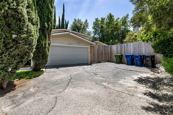 a view of backyard with small cabin and wooden fence