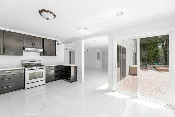 a kitchen with stainless steel appliances kitchen island granite countertop a stove a sink and a refrigerator