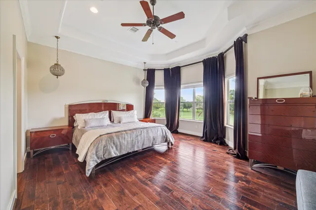 a room with a chair and a view of kitchen appliances with wooden floor