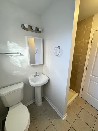 a bathroom with a toilet sink and mirror