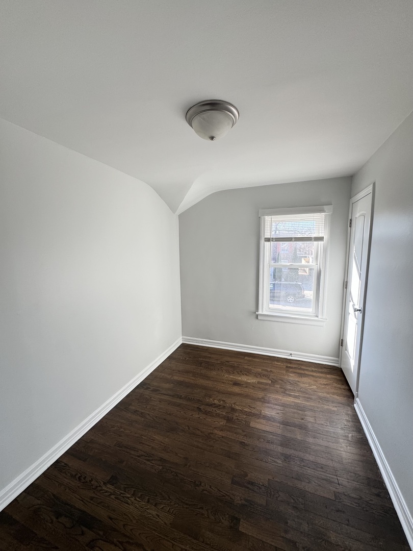 3338 West 83rd Place Chicago, IL 60652 - Photo 12 of 26 an empty room with wooden floor and windows