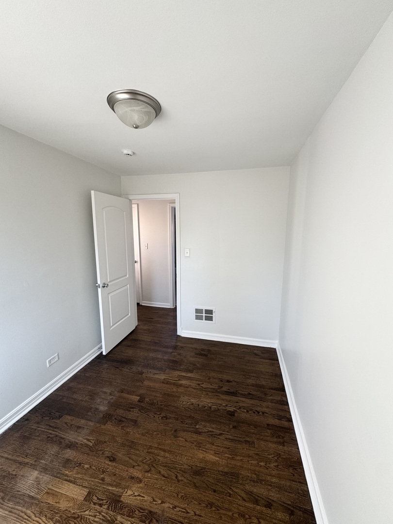 3338 West 83rd Place Chicago, IL 60652 - Photo 13 of 26 an empty room with wooden floor and windows