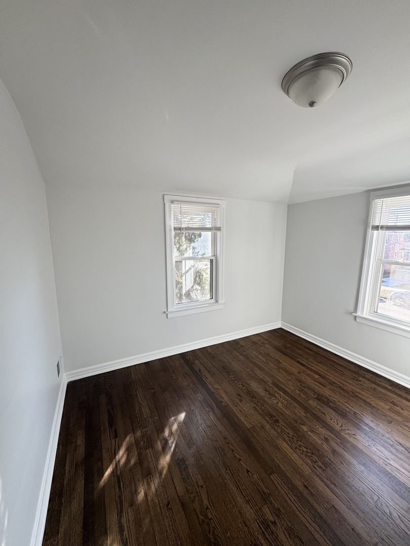 3338 West 83rd Place Chicago, IL 60652 - Photo 14 of 26 an empty room with wooden floor and windows