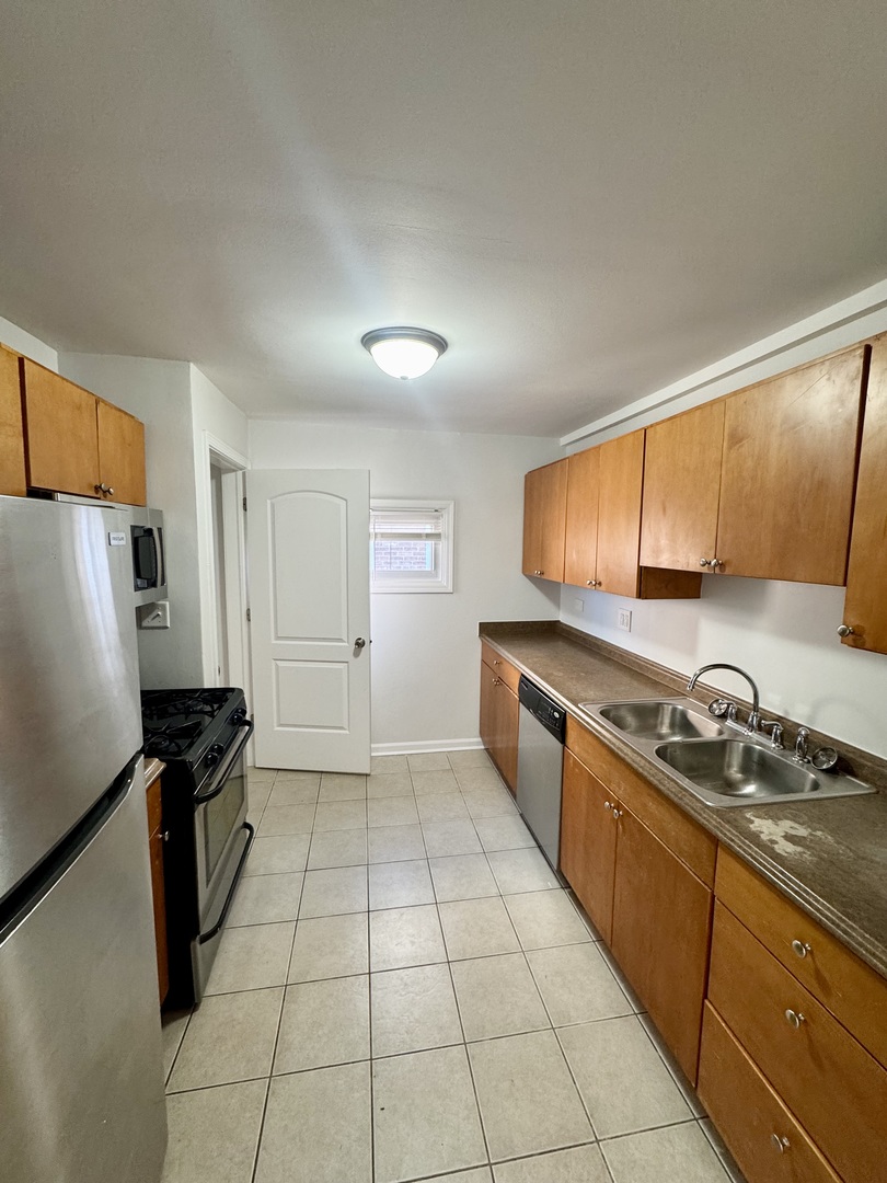 3338 West 83rd Place Chicago, IL 60652 - Photo 4 of 26 a kitchen with granite countertop a refrigerator a sink and wooden cabinets