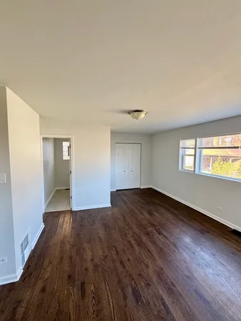 a view of empty room with window and wooden floor