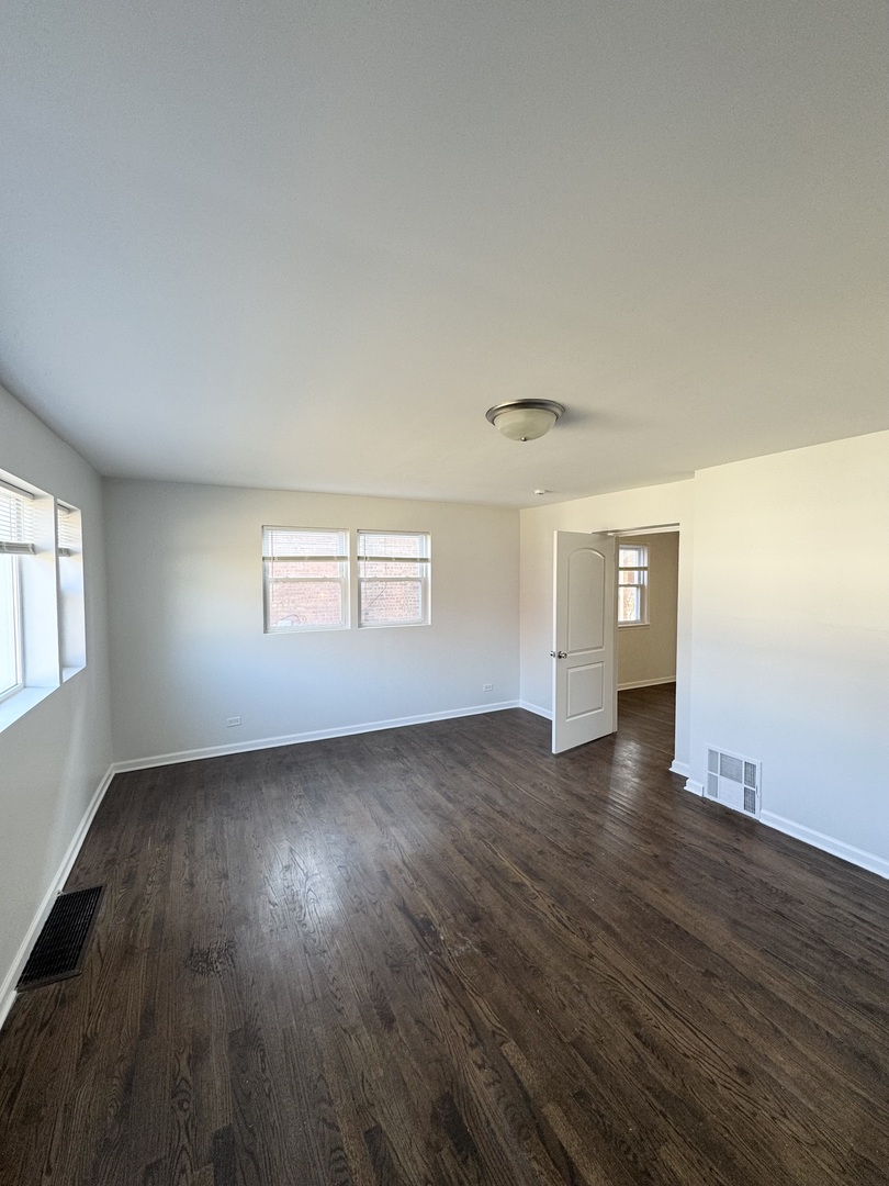 3338 West 83rd Place Chicago, IL 60652 - Photo 8 of 26 an empty room with wooden floor and windows