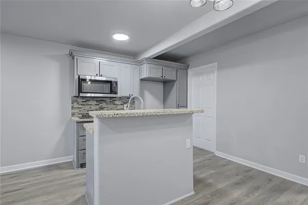 a kitchen with kitchen island a counter top space a sink and cabinets