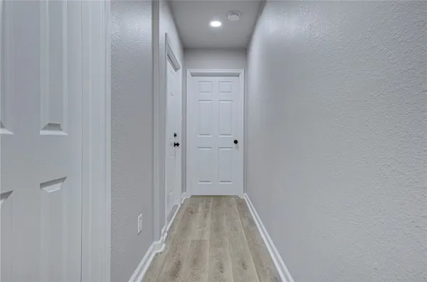 a view of a hallway with wooden floor