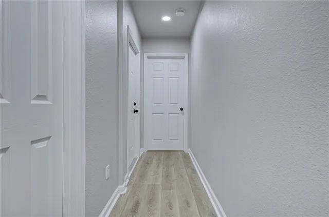 a view of a hallway with wooden floor