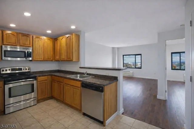 a kitchen with stainless steel appliances granite countertop a stove a sink and a microwave