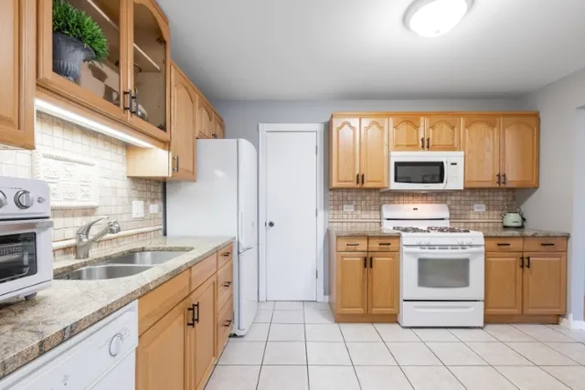 a kitchen with stainless steel appliances granite countertop a stove a sink and a microwave