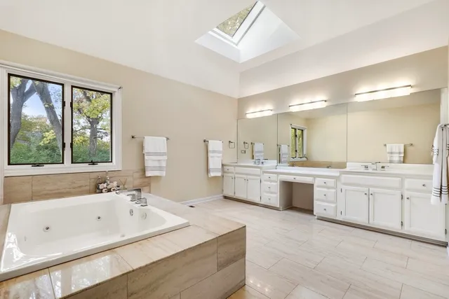 a large bathroom with a double vanity sink a bathtub and mirror