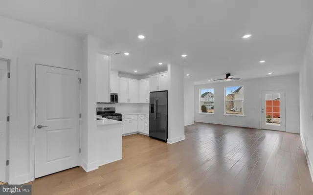 a view of kitchen with refrigerator stove and wooden floor