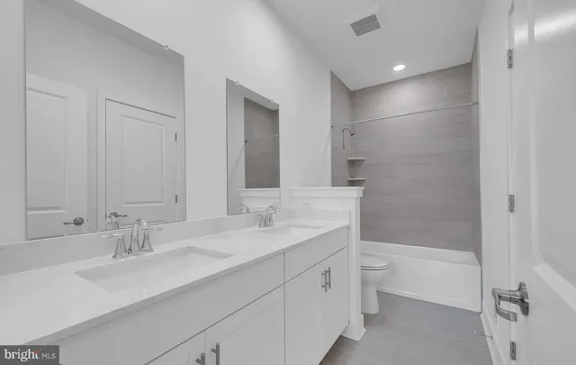 a bathroom with a sink double vanity granite tub and shower