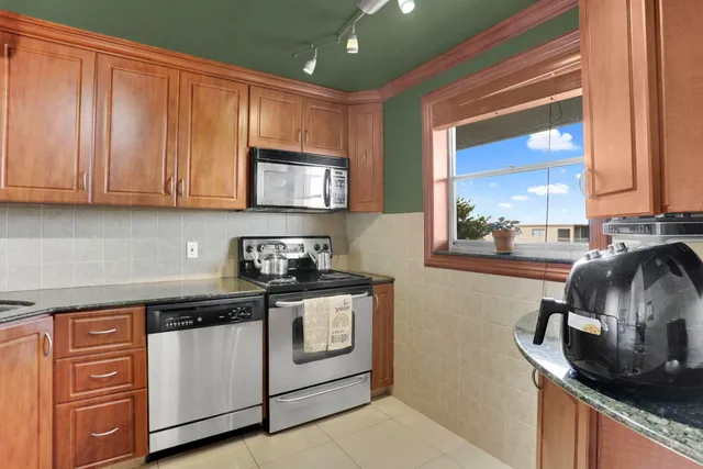 a kitchen with stainless steel appliances granite countertop a sink stove and cabinets