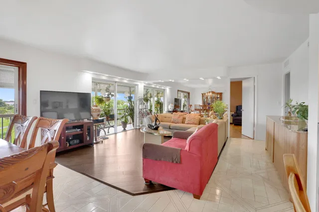a living room with furniture and a dining table with kitchen view