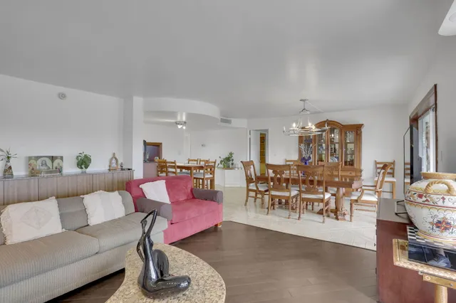 a living room with furniture and a flat screen tv with kitchen view