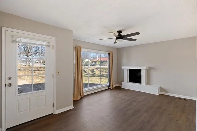 an empty room with fan and windows