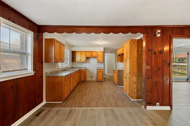 a kitchen with granite countertop cabinets sink and window