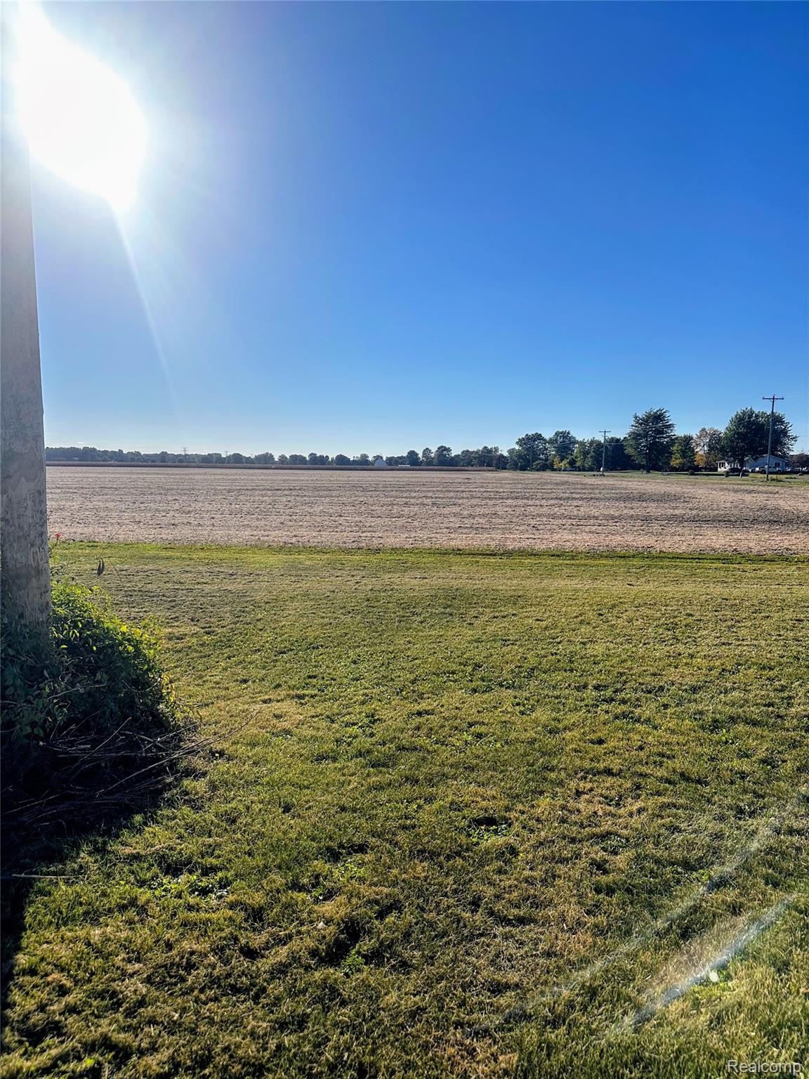 7305 West Gary Road Chesaning, MI 48616 - Photo 7 of 27 Expansive land parcel featuring a clear sky, open field, and distant foliage