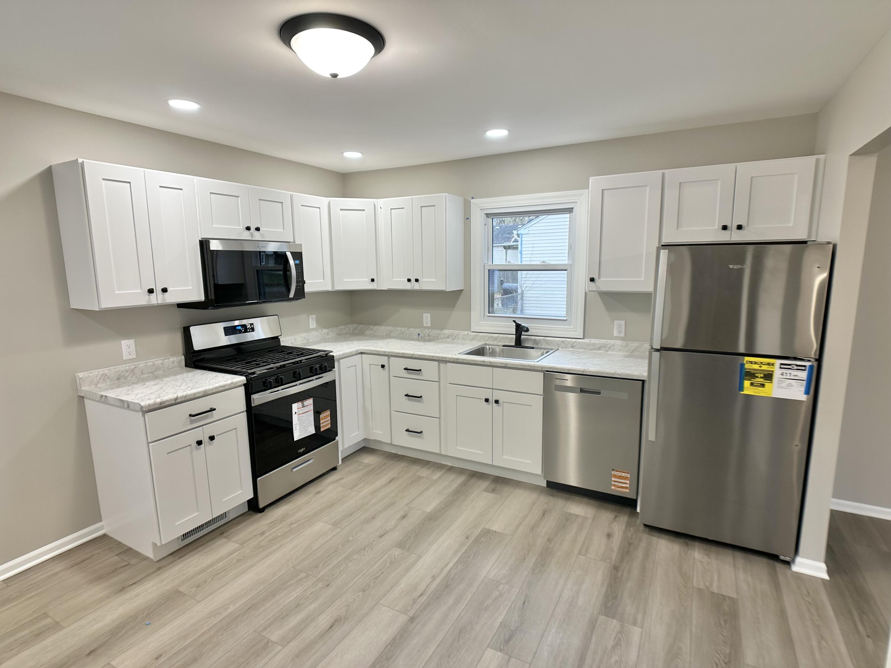 306 Maple Street Crown Point, IN 46307 - Photo 2 of 21 a kitchen with white cabinets stainless steel appliances and a refrigerator