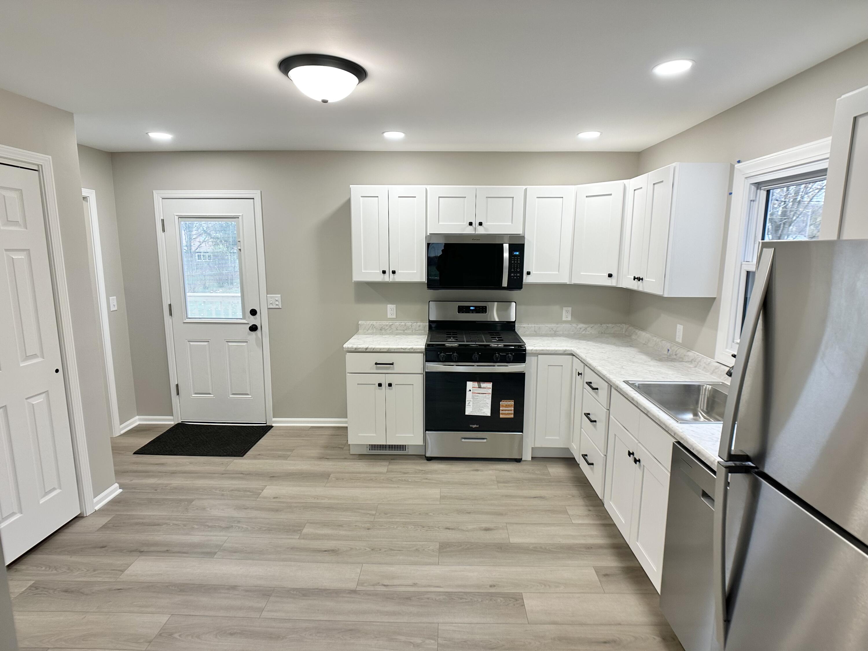306 Maple Street Crown Point, IN 46307 - Photo 3 of 21 a kitchen with white cabinets and stainless steel appliances