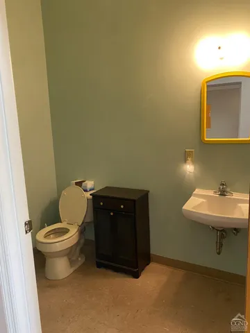 a bathroom with a toilet sink and mirror