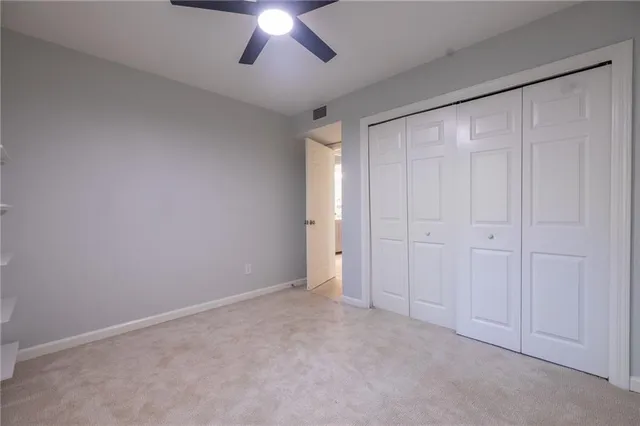 a view of an empty room and a chandelier fan