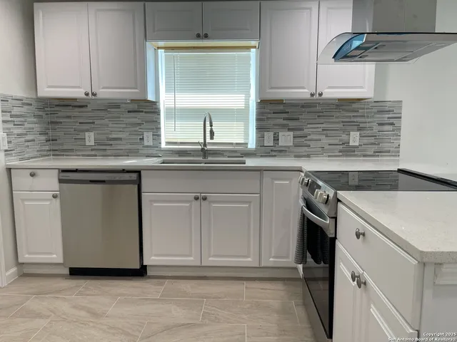 a kitchen with stainless steel appliances granite countertop a sink and a stove