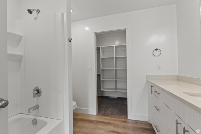 3410 South 1010th Street West Logan, UT 84321 - Photo 10 of 15 Bathroom featuring vanity, light wood-style floors, a spacious closet, and washtub / shower combination