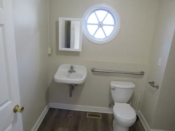 a bathroom with a toilet a sink and a window