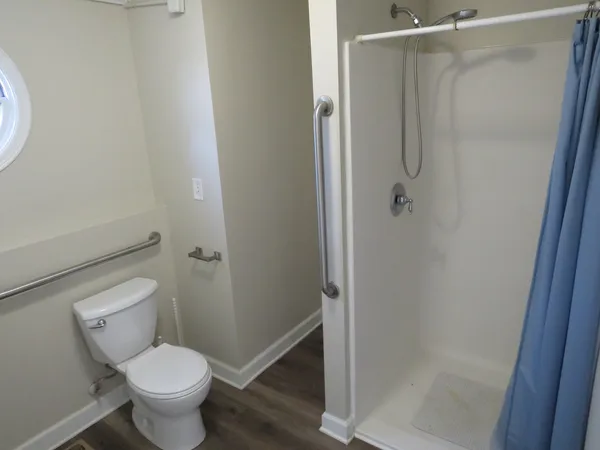 a white toilet sitting next to a shower