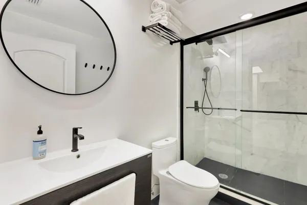 a bathroom with a sink mirror toilet and shower