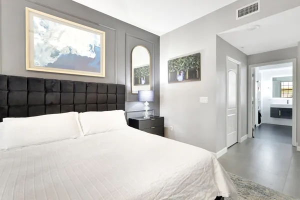 a bedroom with a large bed and wooden floor