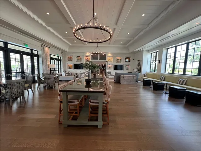 a living room with furniture large window and wooden floor