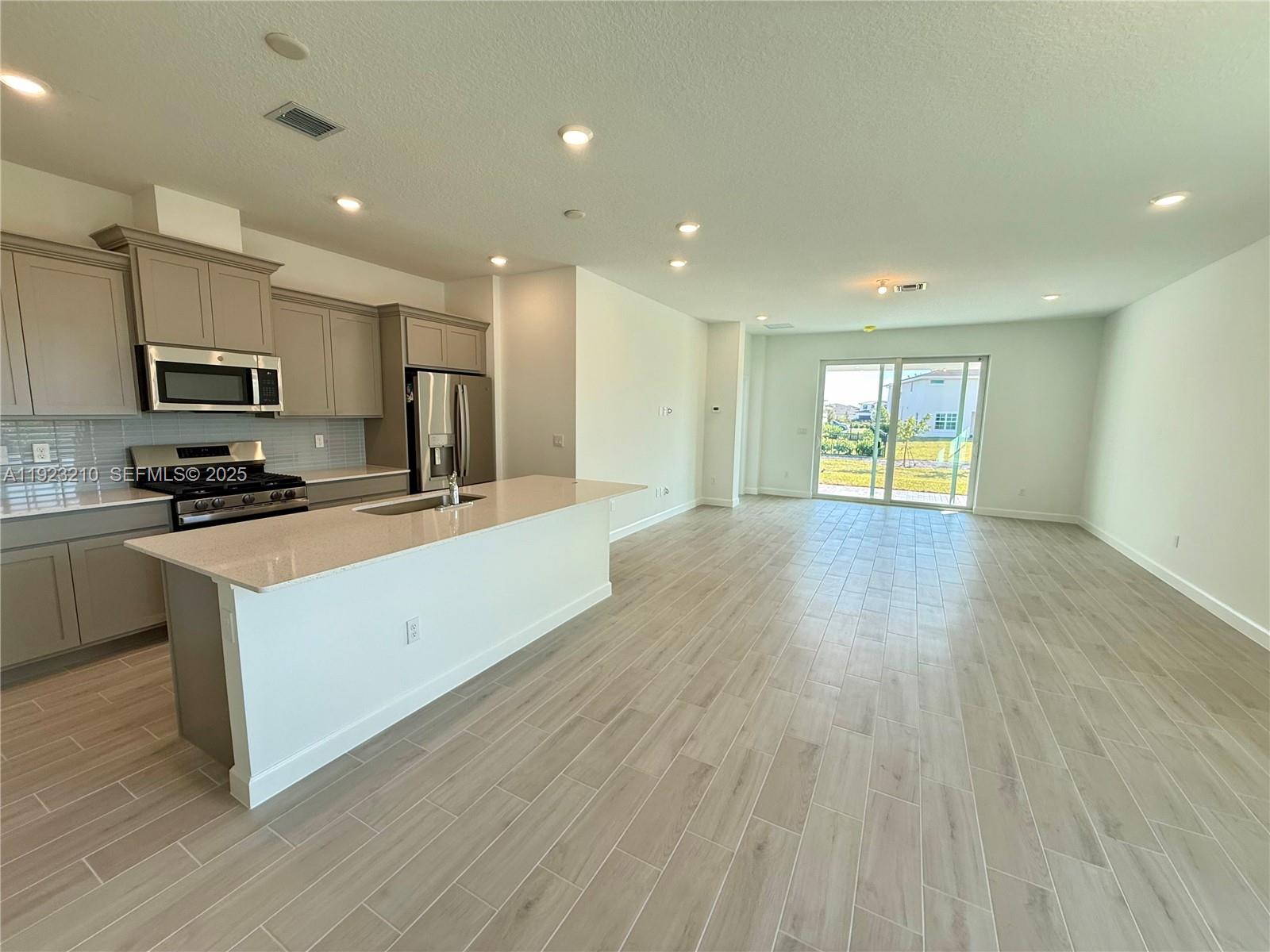 19600 Whispering Creek Road, Unit 19600 West Palm Beach, FL 33470 - Photo 3 of 26 a kitchen with stainless steel appliances a refrigerator sink and microwave