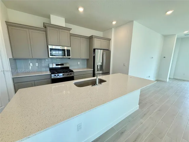 a kitchen with stainless steel appliances a refrigerator sink a stove a microwave and cabinets