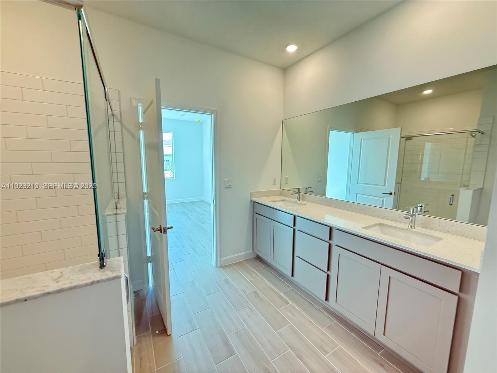 19600 Whispering Creek Road, Unit 19600 West Palm Beach, FL 33470 - Photo 8 of 26 a bathroom with a double vanity sink a mirror and a shower
