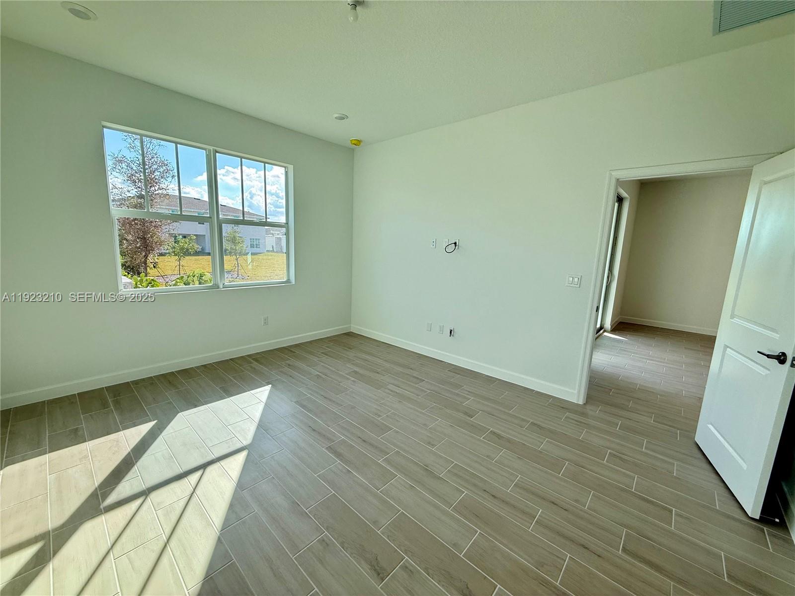 19600 Whispering Creek Road, Unit 19600 West Palm Beach, FL 33470 - Photo 10 of 26 a view of wooden floor and windows in a room